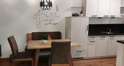 a kitchen with a table and chairs and a kitchen with a kitchen at Residence Maximilian in Vipiteno