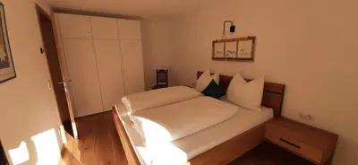 a small bedroom with a bed with white sheets at Residence Maximilian in Vipiteno