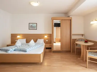 a hotel room with a bed and a table at Hotel B&B Martha in Brunico