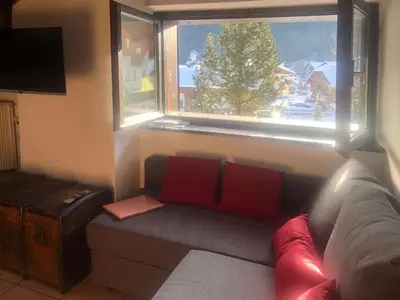 a living room with a couch and a window at Mansarda Marmolada Canazei, parking, ski slopes 300m in Alba di Canazei