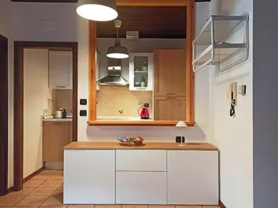 a kitchen with white cabinets and a counter at Mansarda Marmolada Canazei, parking, ski slopes 300m in Alba di Canazei