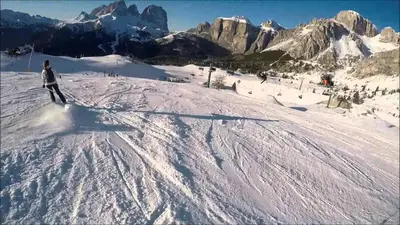 a person riding a snowboard down a snow covered slope at Mansarda Marmolada Canazei, parking, ski slopes 300m in Alba di Canazei