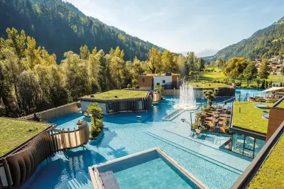 an aerial view of a pool with a waterfall at Quellenhof See Lodge in Saltusio