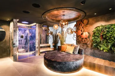 a living room with a circular couch and plants at Quellenhof See Lodge in Saltusio