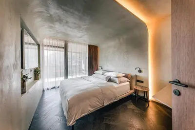 a bedroom with a large bed and a large window at Quellenhof See Lodge in Saltusio
