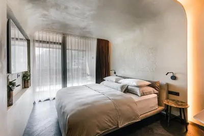 a bedroom with a large bed and a large window at Quellenhof See Lodge in Saltusio