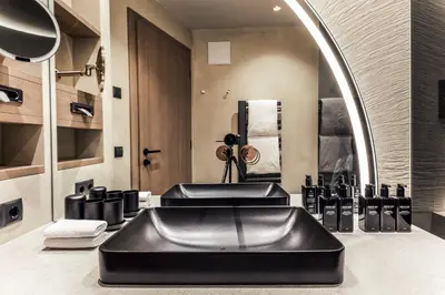 a bathroom with a black sink and a mirror at Quellenhof See Lodge in Saltusio