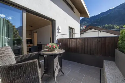 a patio with a table and chairs on a balcony at Apartments Dami in Ortisei