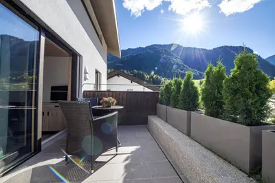 a balcony with chairs and a view of the mountains at Apartments Dami in Ortisei