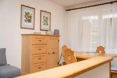 a dining room with a table and a dresser at Ladurner Home in Brunico