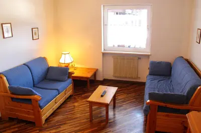 a living room with two blue couches and a table at Residence Casa Cavalese in Cavalese