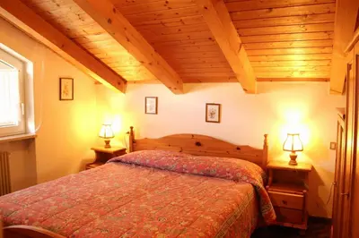 a bedroom with a bed and two lamps on tables at Residence Casa Cavalese in Cavalese