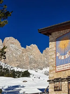 a sign on the side of a building in the snow at Groden Apartments in Santa Cristina in Val Gardena