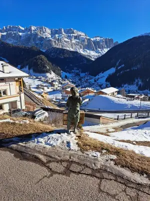 a person standing on a bench in the snow at Groden Apartments in Santa Cristina in Val Gardena
