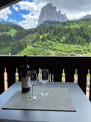 two wine glasses sitting on a table with a view at Apartments Mezdi in Santa Cristina in Val Gardena