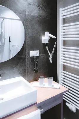 a bathroom with a white sink and a phone at Anewandterhof in Brunico