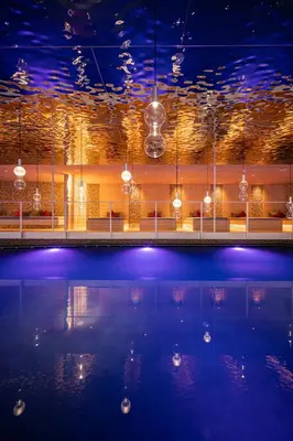 a large swimming pool with lights in a building at Anewandterhof in Brunico