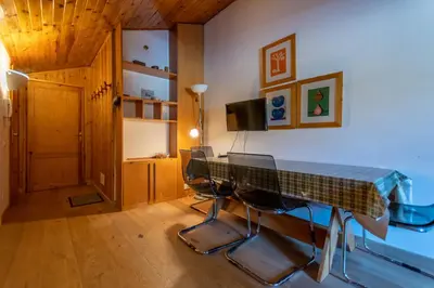 a room with a table with chairs and a television at Casa Val di Fassa in Canazei