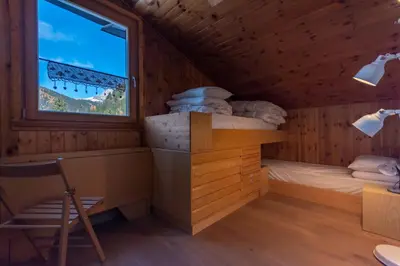 a room with a bed and a window in a cabin at Casa Val di Fassa in Canazei