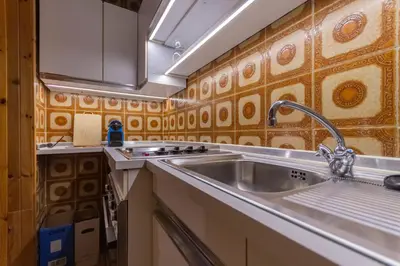 a kitchen with a sink and a stove at Casa Val di Fassa in Canazei