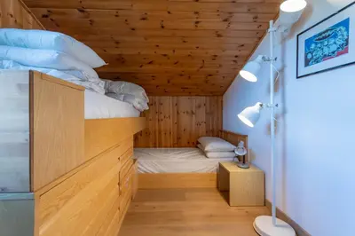 a bed in a room with a wooden ceiling at Casa Val di Fassa in Canazei