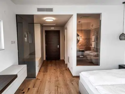 a bedroom with a bed and a living room at Pitla Cuna - Eco Relais in Terlano