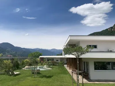 a building with a yard with benches and a pool at Pitla Cuna - Eco Relais in Terlano