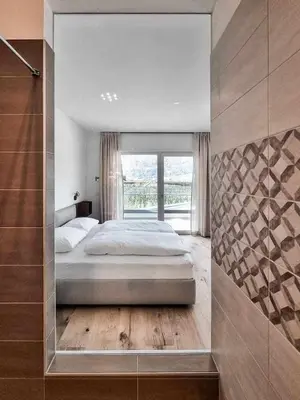 a bedroom with a large bed and a large window at Pitla Cuna - Eco Relais in Terlano
