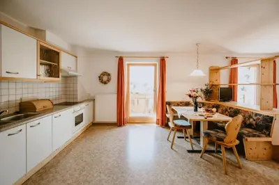 a kitchen with a table and chairs and a dining room at Peintnerhof Appartments & Zimmer in Naz-Sciaves