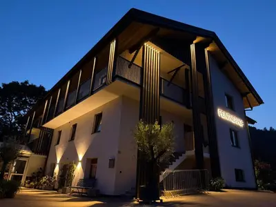 a building with a lit up facade at night at Peintnerhof Appartments & Zimmer in Naz-Sciaves