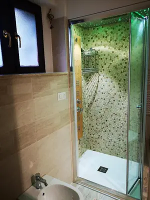 a shower with a glass door in a bathroom at Cortina Comfort House in Cojana