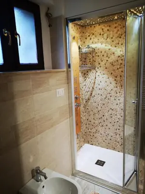 a bathroom with a shower with a sink at Cortina Comfort House in Cojana