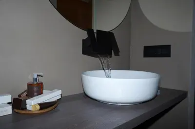 a bathroom sink with water coming out of it at Chalet La Ciaseta in Pozza di Fassa