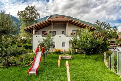 a house with a playground in front of a yard at Lampenhof in Brunico