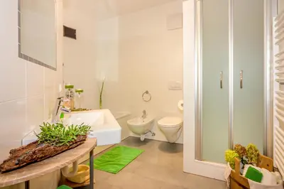 a white bathroom with a toilet and a sink at Lampenhof in Brunico