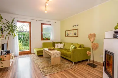 a living room with a green couch and a fireplace at Lampenhof in Brunico