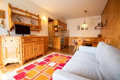 a living room with a couch and a kitchen at A un passo dagli impianti - Penia di Canazei in Penia