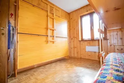 a bedroom with wooden walls and a bed in a room at A un passo dagli impianti - Penia di Canazei in Penia
