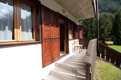 a porch of a house with a bench and windows at A un passo dagli impianti - Penia di Canazei in Penia