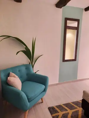 a blue chair in a living room with a mirror at Suite - Sweet MayLeen in Merano