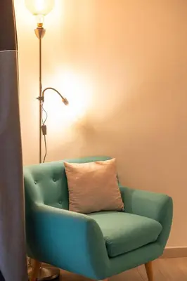 a blue couch with a pillow next to a lamp at Suite - Sweet MayLeen in Merano