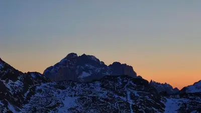 a snow covered mountain with a sunset in the background at Appartamento Blank in Arabba