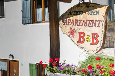 a sign for an open equipment bar with flowers at Appartamento Blank in Arabba