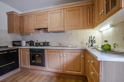 a kitchen with wooden cabinets and a stove top oven at Appartamento Blank in Arabba