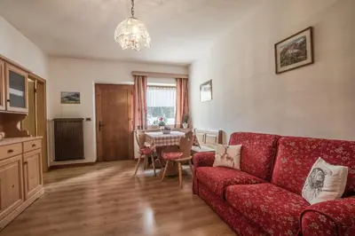 a living room with a red couch and a table at Appartamento Blank in Arabba