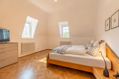 a bedroom with a bed and a flat screen tv at Villa Stubai - Penthouse in the heart of Merano in Merano