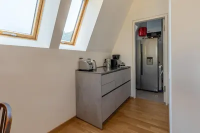 a kitchen with a sink and a refrigerator at Villa Stubai - Penthouse in the heart of Merano in Merano