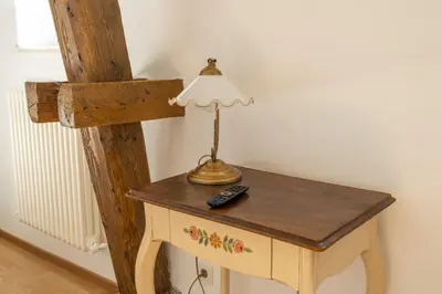 a table with a lamp and a remote control on it at Villa Stubai - Penthouse in the heart of Merano in Merano