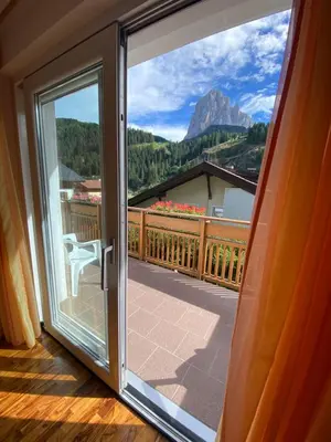 a door to a balcony with a view of a mountain at Amalia Apartment in Santa Cristina in Val Gardena