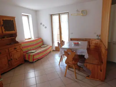 a living room with a table and a couch at Appartamento Zorzi in Ziano di Fiemme